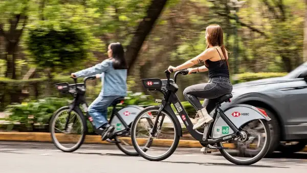 Dos jóvenes pasean a bordo de bicicletas de Ecobici en la Ciudad de México.