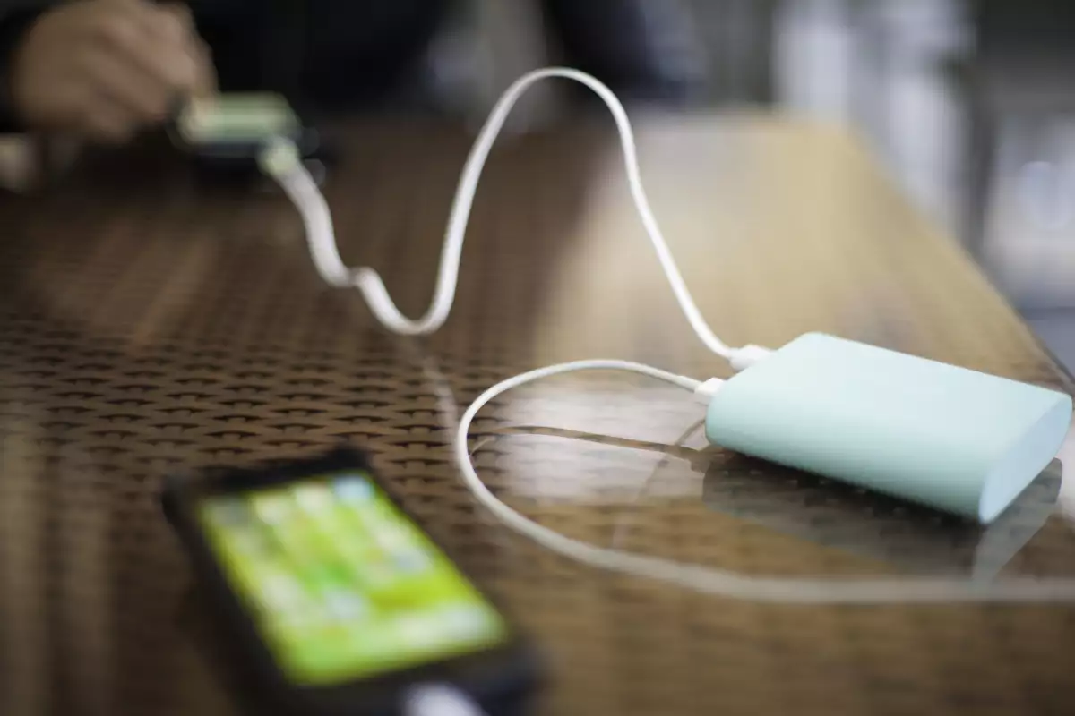 Portable external battery charging two smartphones in use