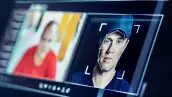 Pantalla de monitor de computadora que muestra el rostro de una persona con vectores de IA para generar una deepfake.