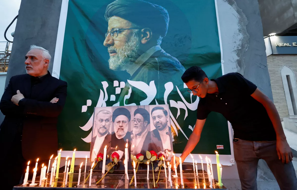 Una persona enciende una vela para ofrecer condolencias por la muerte del presidente de Irán, Ebrahim Raisi, y otros, fuera de la embajada iraní, en Bagdad, Irak, el 20 de mayo de 2024.