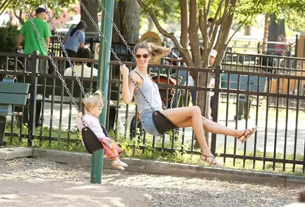 Gisele Bündchen y la pequeña Vivian columpiándose.