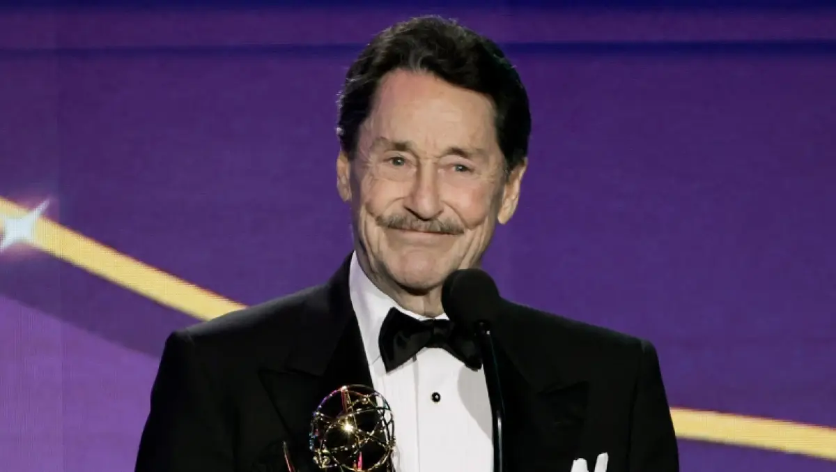 El actor Peter Cullen vestido con un esmoquin sonríe frente en una premiación