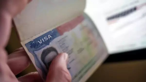 Unknown causian person holding passport with visa