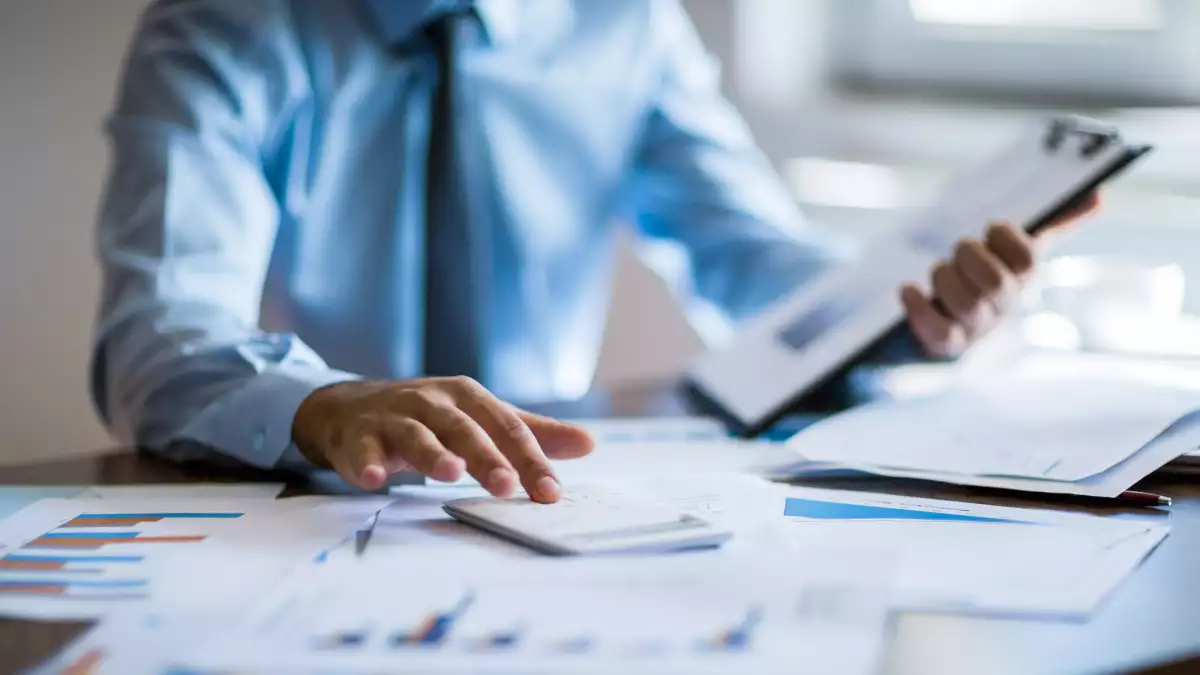 Business accounting concept, Business man using calculator with computer laptop, budget and loan paper in office.