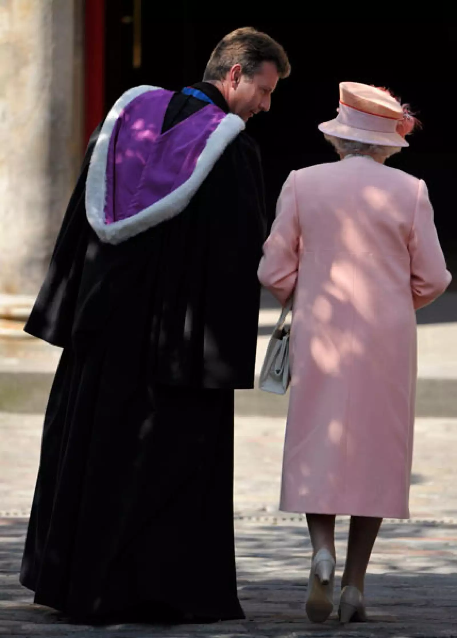 La reina Isabel II, quien lució un vestido en color durazno, platicó con el reverendo antes de la misa.