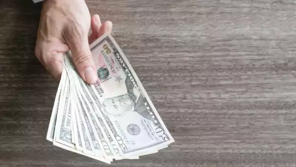 Man holding dollar banknote.young businessman holding money.Business and finances making and saving money concept.