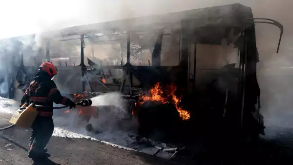 Un bombero apaga un autobús en llamas incendiado por grupos del crimen organizado en respuesta a una operación en Jalisco para detener a un objetivo de seguridad de alta prioridad, en una de las principales avenidas de Zapopan, estado de Jalisco, México, el 22 de febrero de 2026.