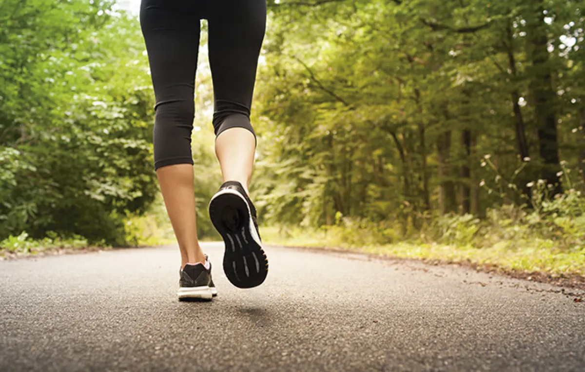 Woman taking a walking running on a country road.  People fitnes