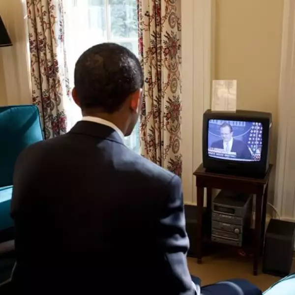 Obama observa en la televisión el primer informe del secretario de prensa en su estudio privado de la Oficina Oval.