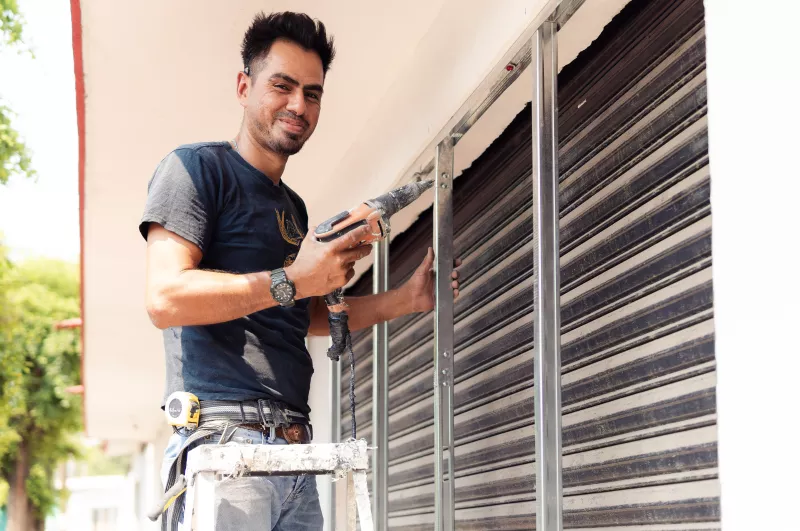 Hombre trabajando en arreglos del exterior de una fachada