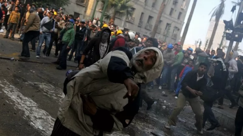 un hombre lanza un proyectil entre la multitud