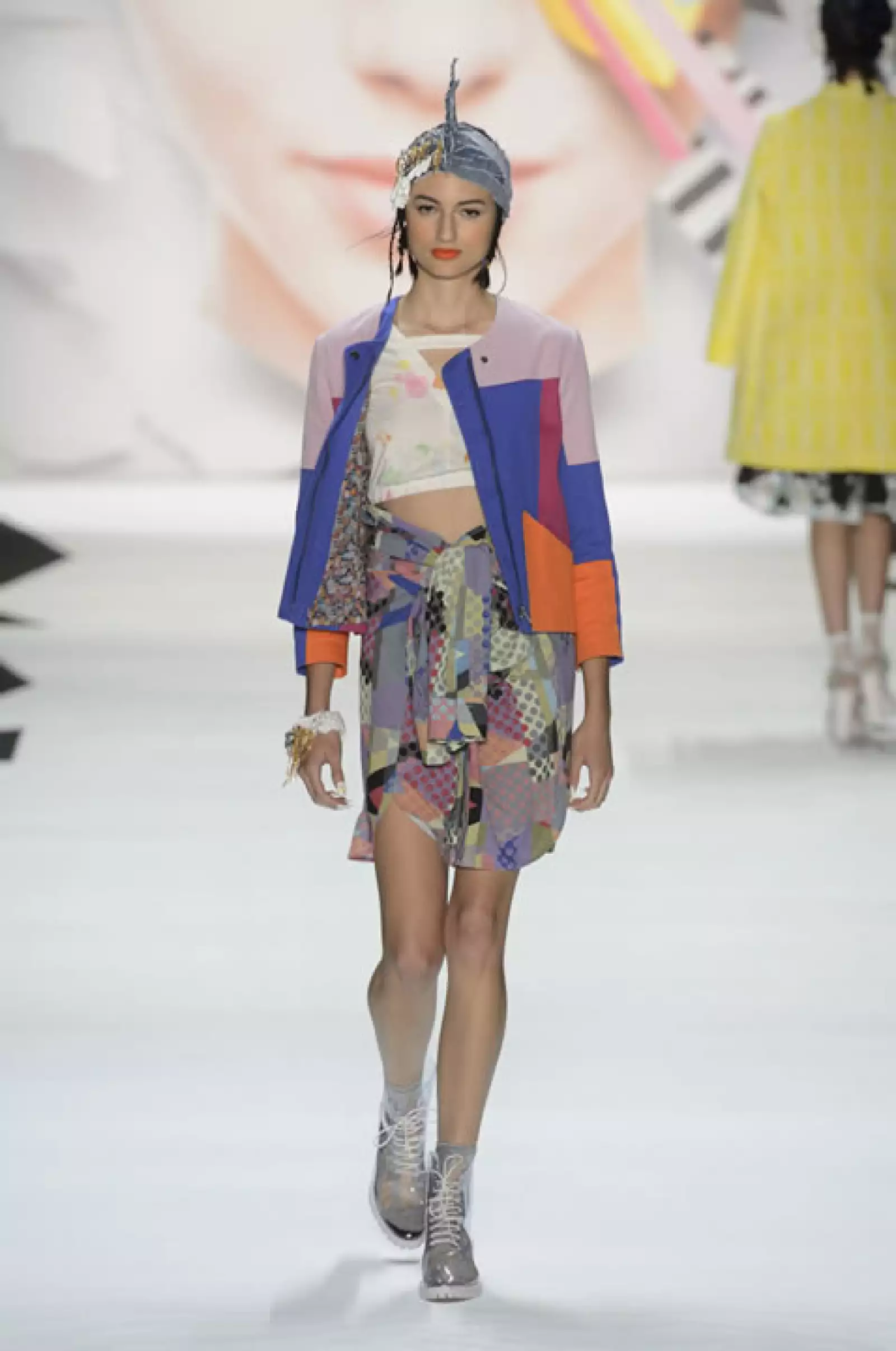 Chamarra color block de algodón sobre crop top pintado. La falda es una blusa de chiffón amarrada, combinada con botas de PVC.