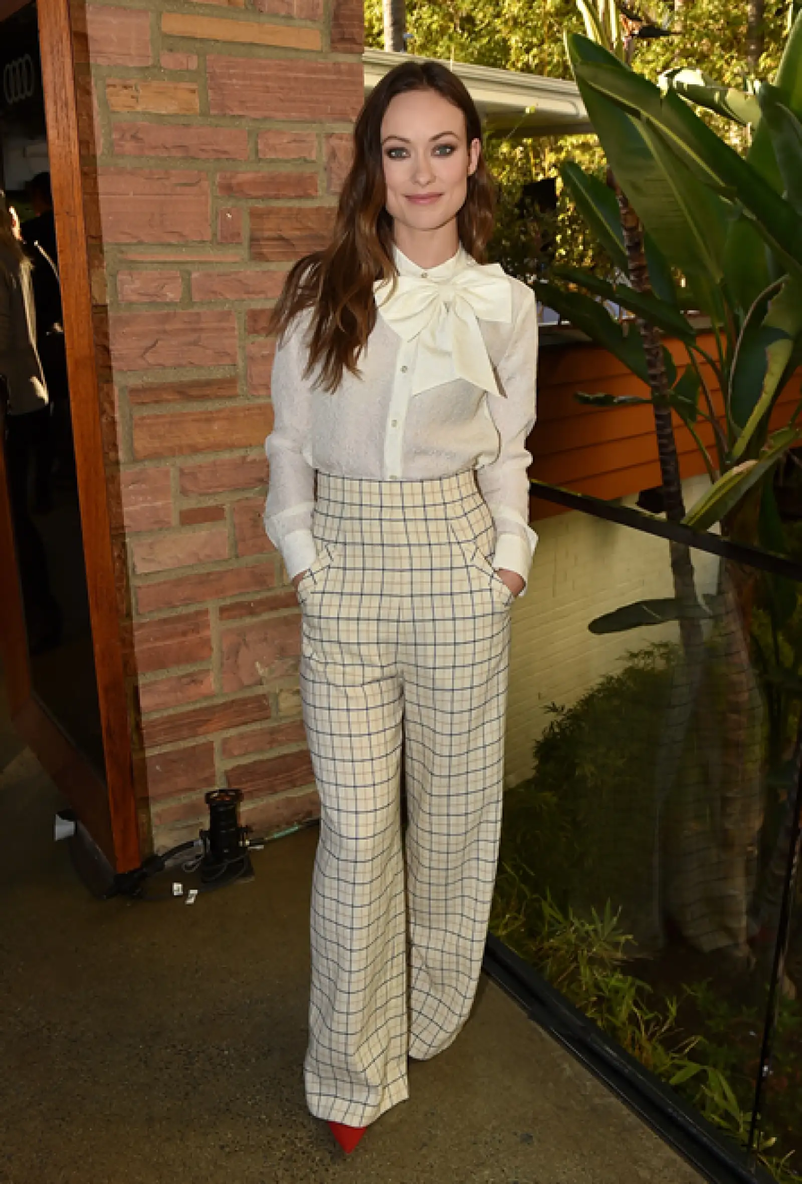 Conquistó el look oficinista con pantalones de cuadros Houghton Fall 2015 y blusa con moño de Kate Spade. Le dio un toque especial con pumps rojos de ante Paul Andrew.