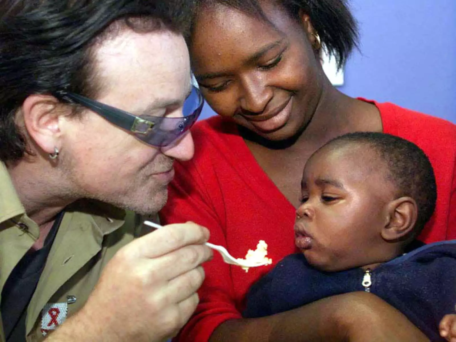 Bono se caracteriza también por ser un activista social. Aquí en África en 2002 alimentando a un pequeño infectado del VIH.