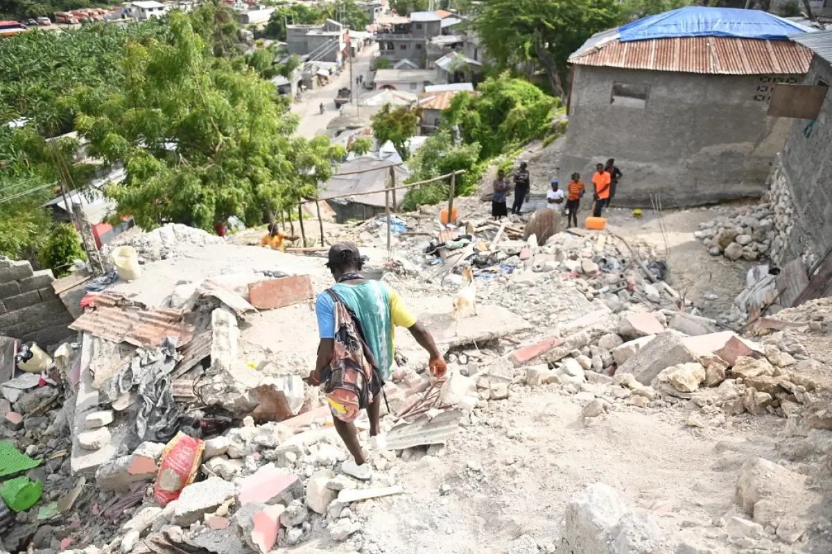 La gente camina entre edificios dañados en Jeremie, Haití, después de que un terremoto golpeara el oeste de Haití el 6 de junio de 2023.