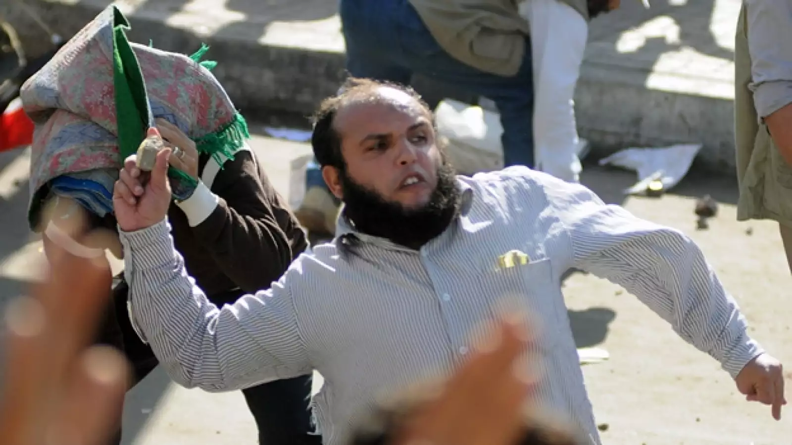 un manifestante laza una piedra