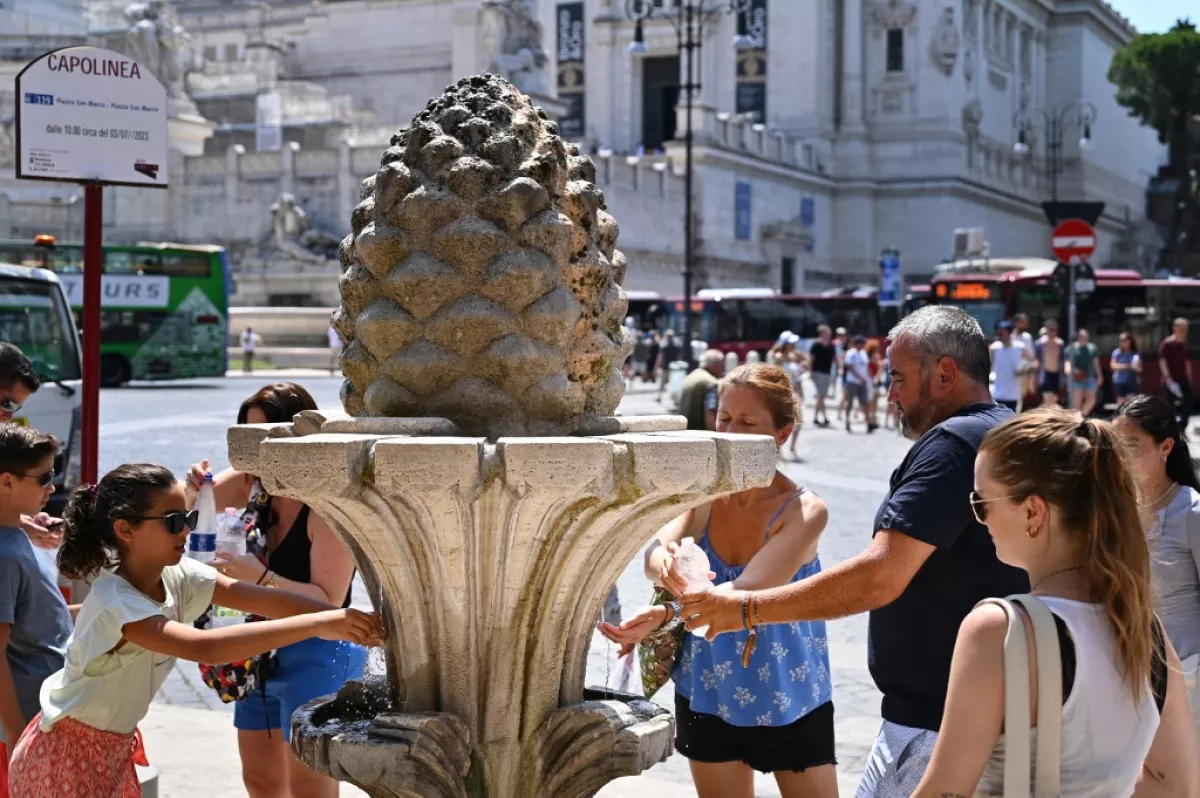 Los miembros del publc llenan las botellas con agua en una fuente de Roma, el 14 de julio de 2023, mientras Italia se ve afectada por una ola de calor.
