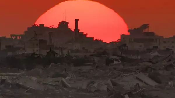 Esta imagen tomada desde una posición en la frontera israelí con la Franja de Gaza, muestra la puesta de sol detrás de edificios destruidos en el territorio palestino sitiado el 19 de agosto de 2025.