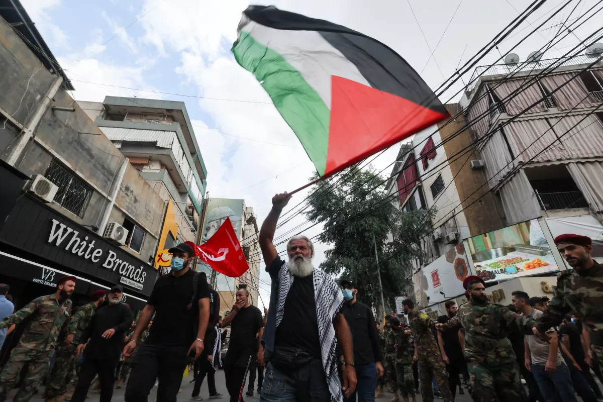 Un hombre ondea una bandera palestina mientras los dolientes se reúnen durante el funeral del líder senior de Hezbolá, Ibrahim Aqil, y el miembro de Hezbolá Mahmoud Hamad, quienes murieron en el ataque israelí del viernes en los suburbios del sur de Beirut, en Beirut, Líbano, el 22 de septiembre de 2024.