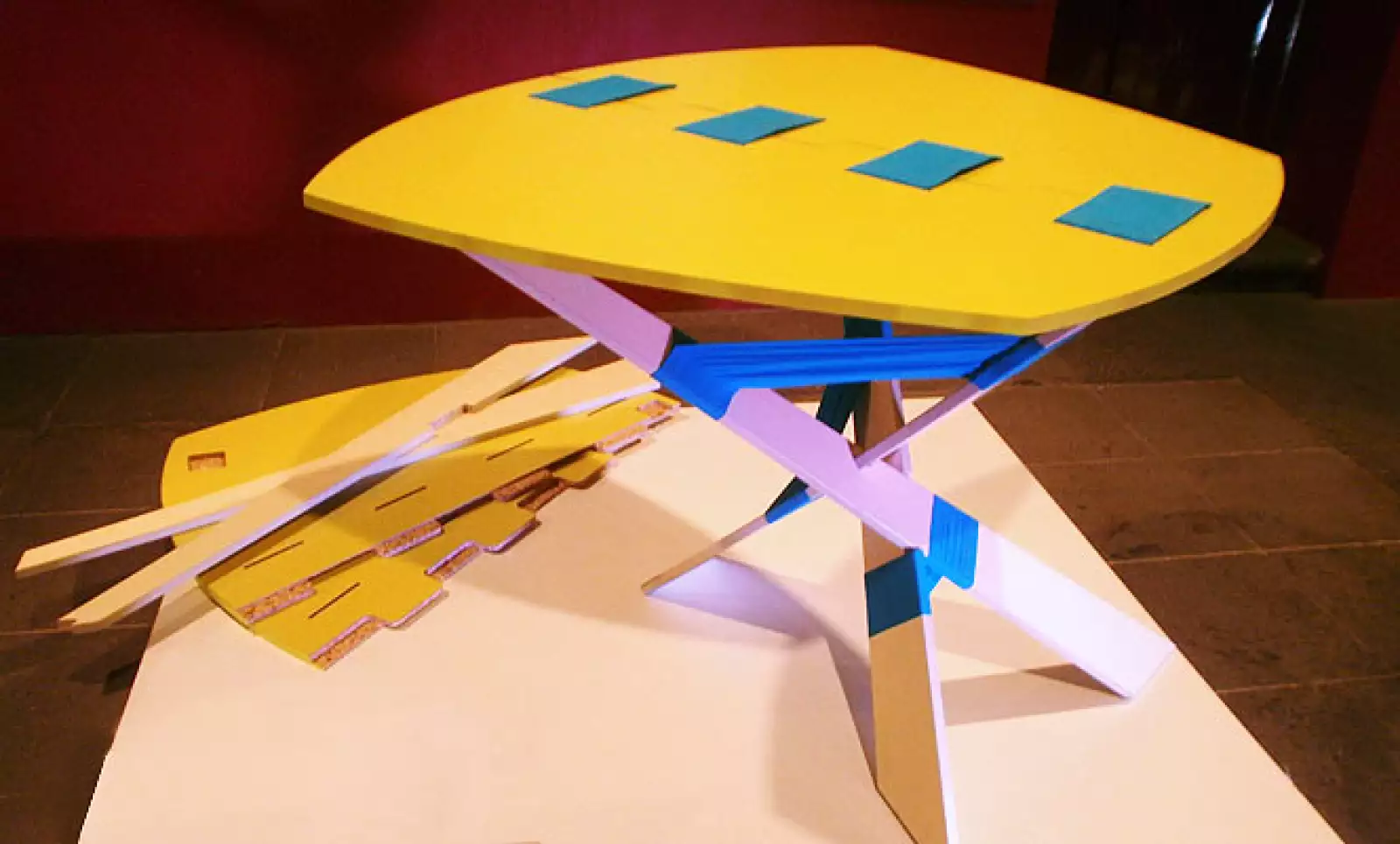 7.	Trip es una mesa que consta de tres patas y dos piezas unidas con tela que forman la cubierta. El ensamble se logra por medio de amarres con cintas y ranuras, sin utilizar herrajes y adhesivos, esto hace más fácil su instalación y transporte. Diseño: U