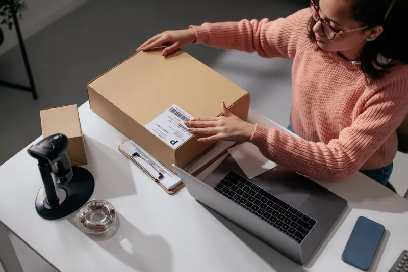 Person handling a box at a modern desk