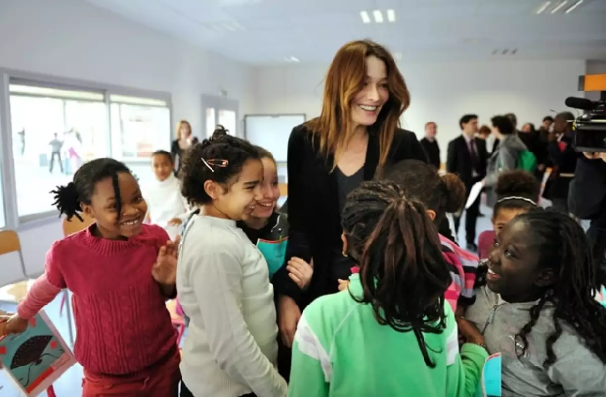 La esposa de Nicolás Sarkozy vistió ayer la escuela primaria Olympe de Gouges de un barrio con dificultades, ahí convivió con los 50 alumnos que integran el coro de Bondy.