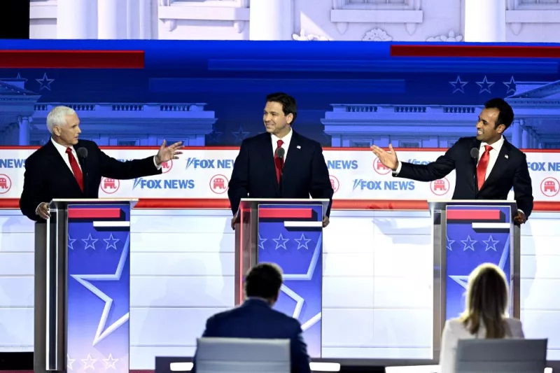 El ex vicepresidente de EE. UU. Mike Pence (ior.) y el empresario y autor Vivek Ramaswamy (l-R) se dirigen hacia el gobernador de Florida, Ron DeSantis, durante el primer debate de las primarias presidenciales republicanas en el Foro Fiserv en Milwaukee, Wisconsin, el 23 de agosto de 2023.