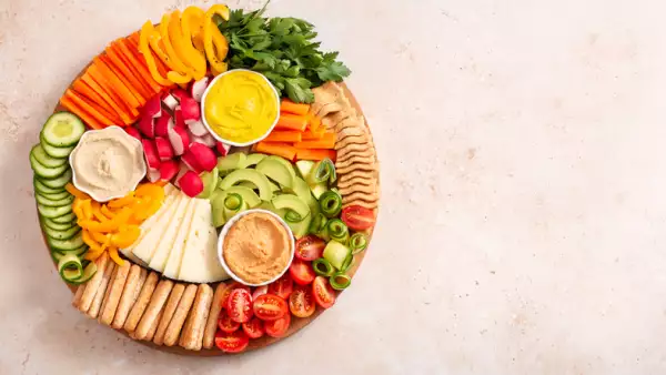 Colorful vegan Charcuterie board with raw vegetables and whole wheat snacks