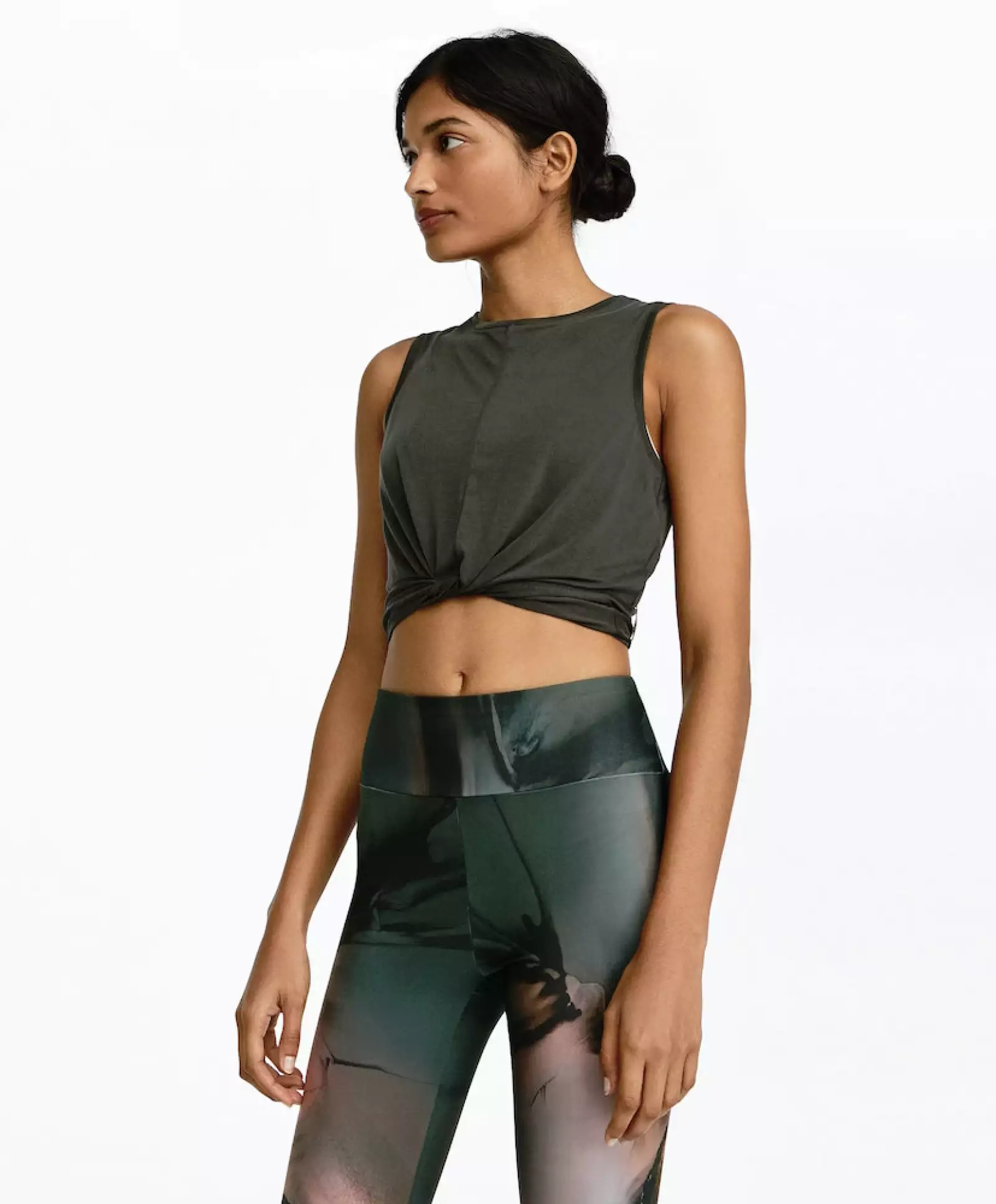 Una playera sin mangas en verde seco (básico) que combine con el estampado de tus leggins, muestra ese six pack, con el detalle del top que aparenta un nudo adelante. 
Oysho.com / Top: $449, leggins: $799