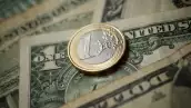 moneda de un euro sobre billete de un dolar