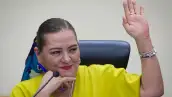 En la imagen se ve Guadalupe Taddei levantando la mano izquierda en una sesión del INE. 