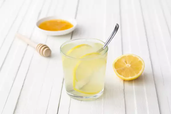 Lemon water in a glass on a white background