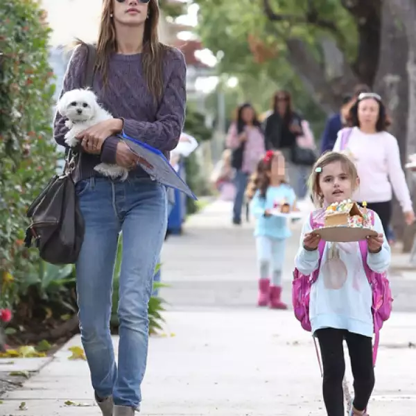 Alessandra Ambrosio fue captada recogiendo a su hija Anja de la escuela mientras ésta presumía la tradicional casita de jenjibre entre sus manos. Alessandra  por su parte cargaba a su perrita Lola.