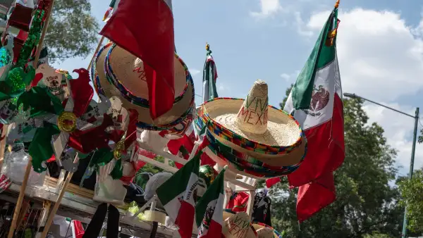 Carro de venta de artículos patrios se instala en la colonia Roma Norte. Hay sombreros, banderas y regiletes. 
