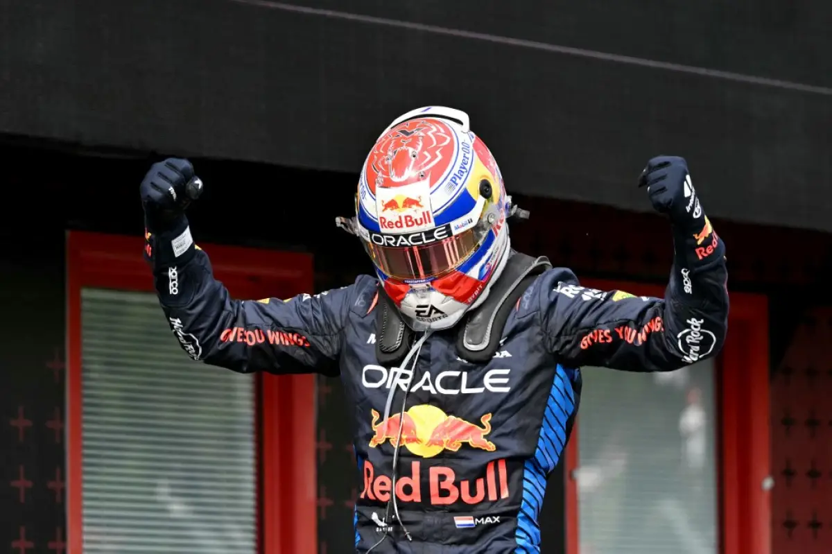 foto de max verstappen levantando los brazos y con el casco puesto tras ganar el primer lugar en la f1 imola 2024