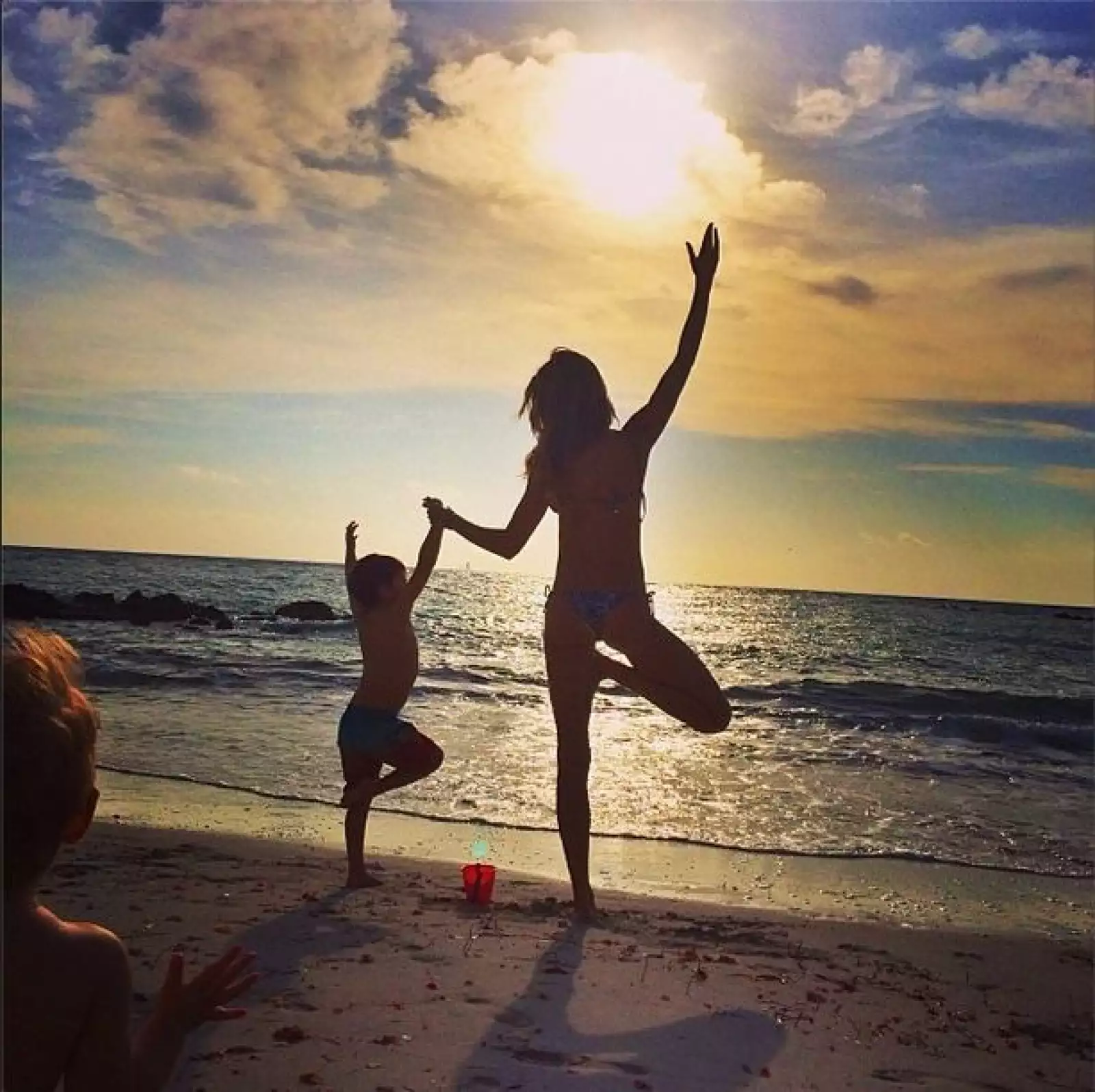Aquí la vemos practicando yoga con su hijo Benjamin frente al mar.