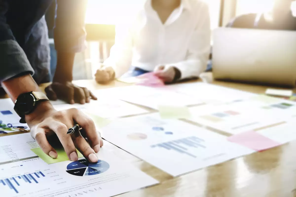 Businessman holding pens and holding graph paper are meeting to plan sales to meet targets set in next year.