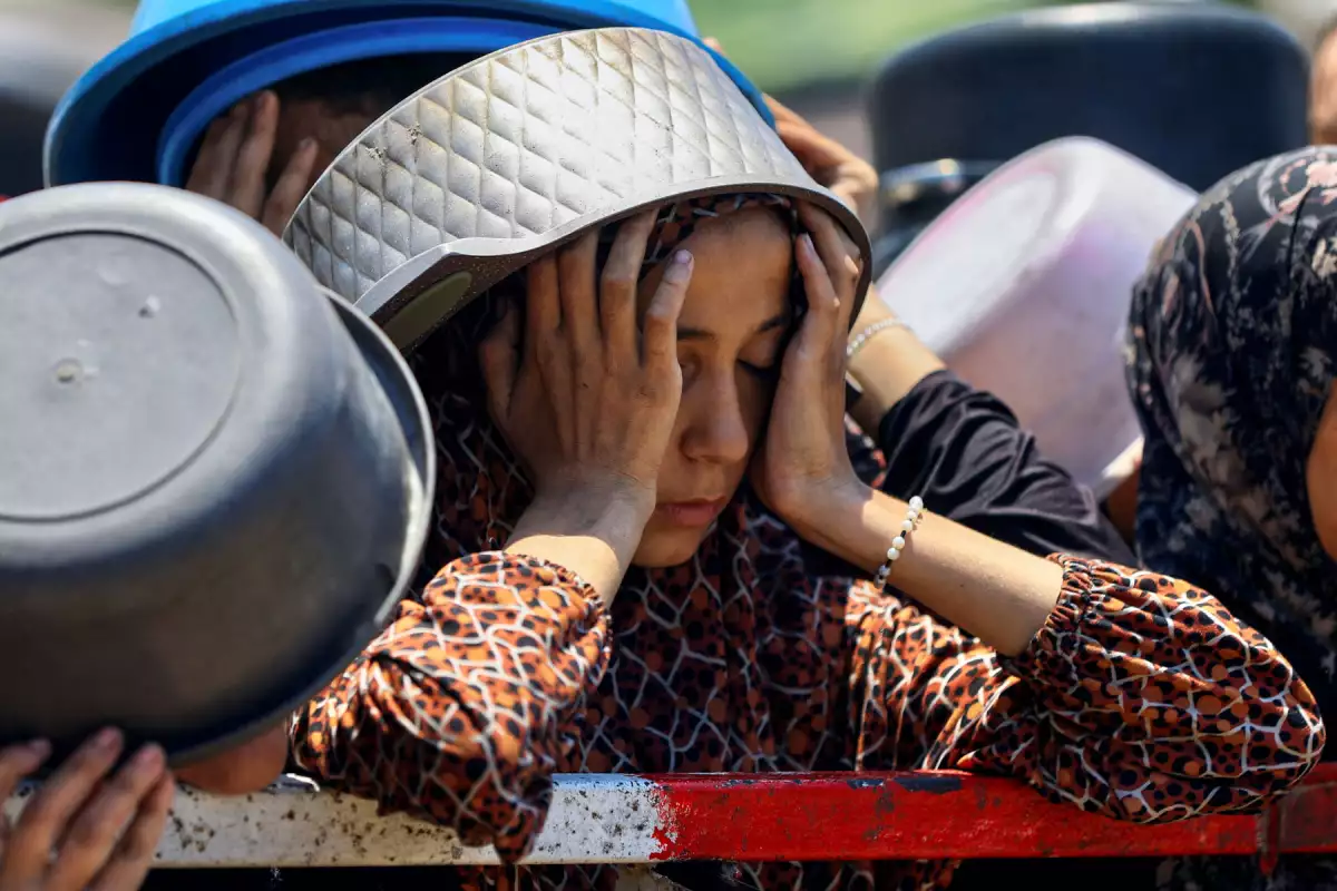 Una niña palestina reacciona mientras espera recibir comida de una cocina benéfica, en medio de una crisis de hambre, en la ciudad de Gaza, el 22 de julio de 2025.