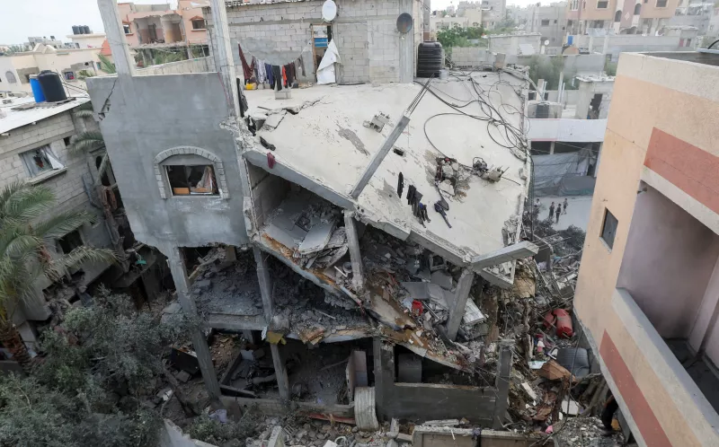 Los palestinos inspeccionan los daños en el lugar de un ataque israelí en una casa, en el centro de la Franja de Gaza, el 18 de mayo de 2025.