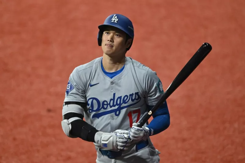 foto de shohei ohtani, jugador estrella de los angeles dodgers, carga un bat entre sus manos.