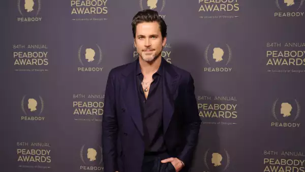 Matt Bomer en los Peabody Awards vistiendo un traje oscuro y una camisa negra desabotonada.