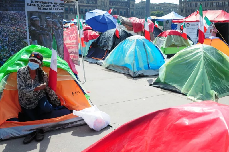 Una mujer sale de una casa de campaña en el campamento del FRENA.