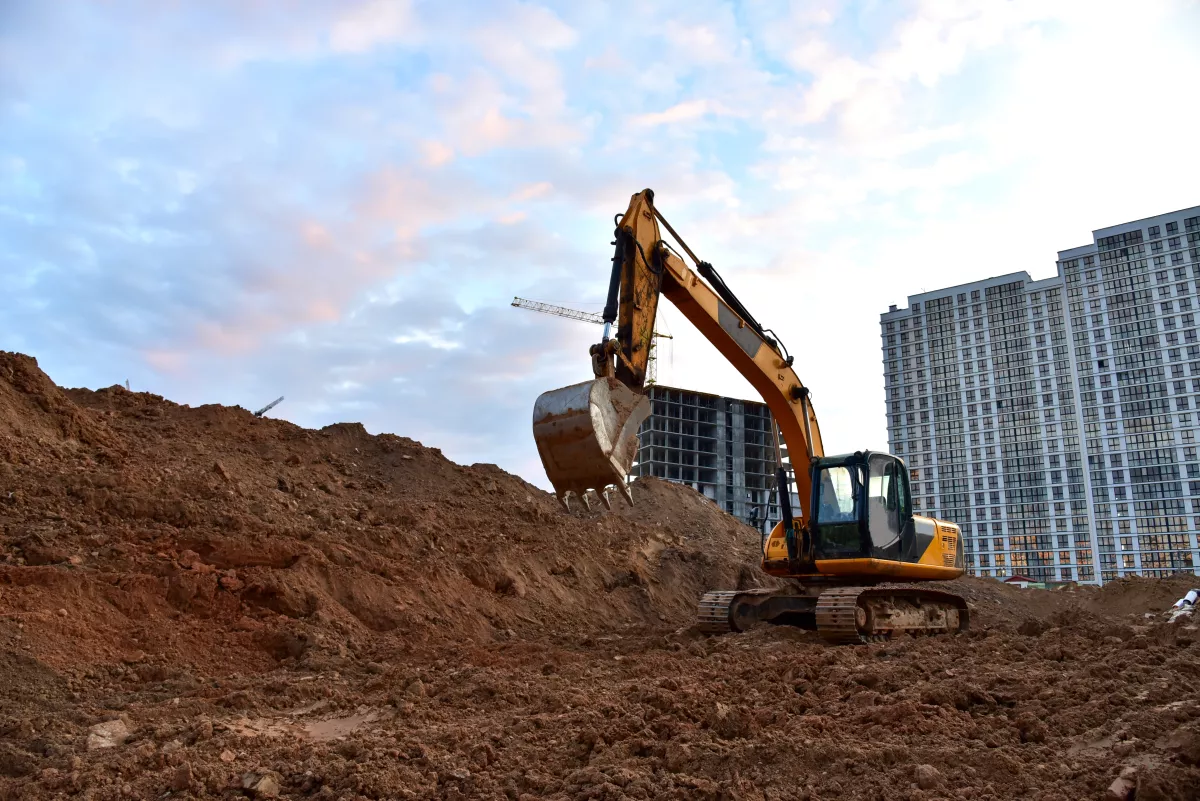 Excavator during earthmoving at construction site on sunset background. onstruction machinery for excavating.