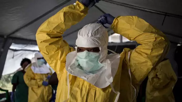 Una trabajadora médica se pone su Equipo de Protección Personal (EPP) antes de entrar en un Centro de Tratamiento del Ébola dirigido por la Alianza para la Acción Médica Internacional (ALIMA) el 12 de agosto de 2018, en Beni.