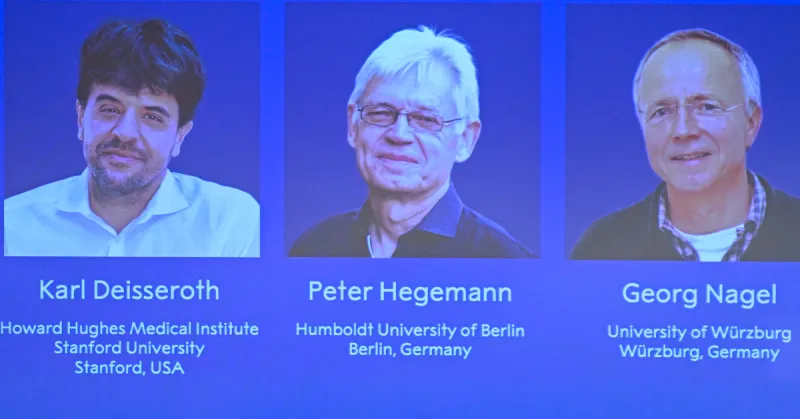 Tres fotos con fondo azul de tres hombres, dos con lentes. Karl, Peter y Georg, ganadores del Premio Nobel de Medicina 2026.jpg
