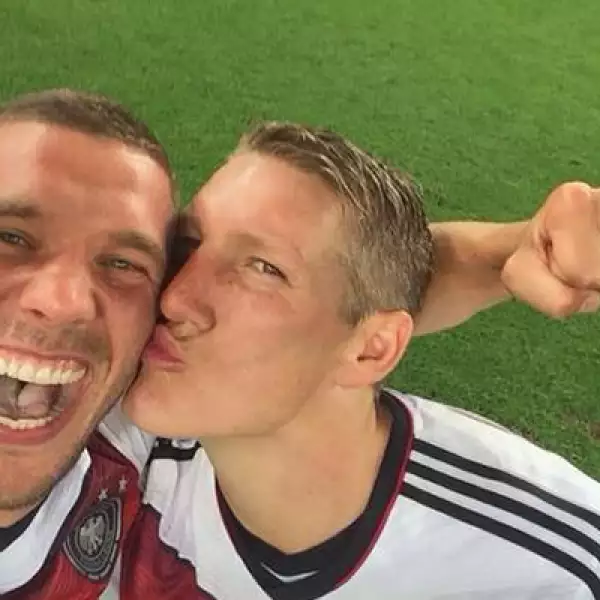 Podolski  recibe un beso de Bastian Schweinsteiger en la celebración de la Copa del Mundo.