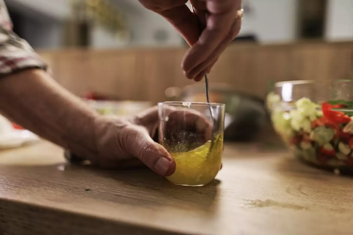 Senior couple preparing a healthy vegetable salad at home.