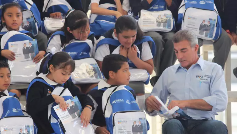 Reunido con estudiantes de primaria, a quienes entregó mochilas con su firma.