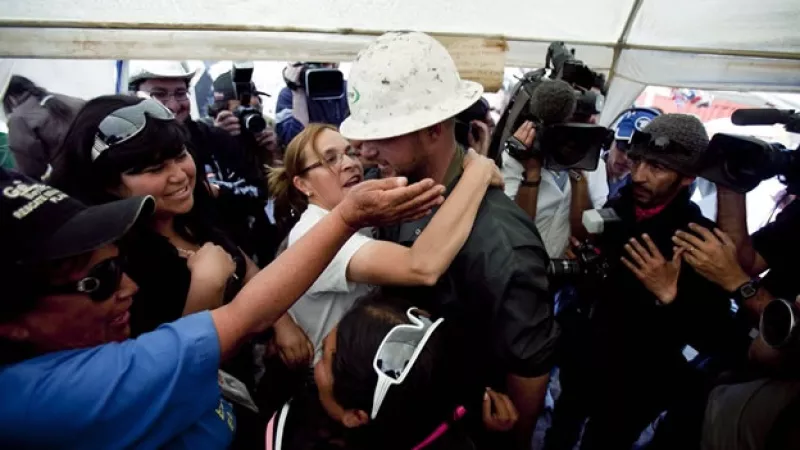familiares de mineros abrazan a un operador
