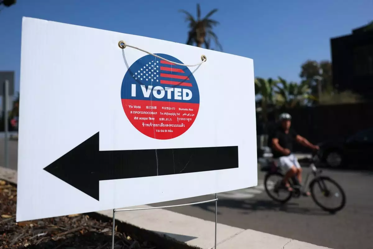Un ciclista pasa por un cartel de I Voted afuera en un centro de votación durante la votación anticipada en persona para las elecciones especiales de la Proposición 50 de California en Los Ángeles, California, el 27 de octubre de 2025.